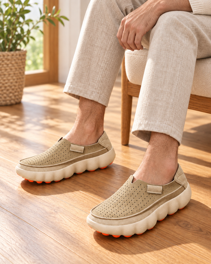 Avelisse Apricot loafers on male legs with oatmeal trousers, seated indoors